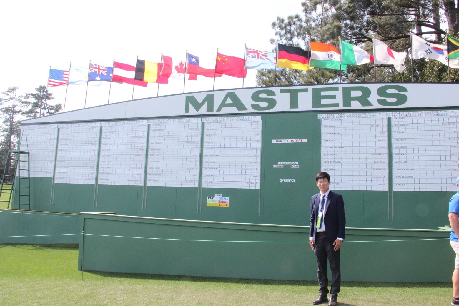 Jittisak Tamprasert beside the Masters scoreboard.